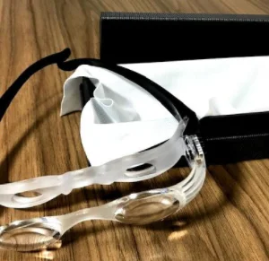 ÓCULOS COM LENTE TRANSPARENTE E ARMAÇÃO PRETA, POSSUI AJUSTES NAS DUAS LATERAIS DO ÓCULOS PARA AJUSTAR A LENTE.