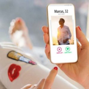 Foto de uma pessoa segurando o celular utilizando aplicativo de paquera