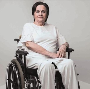 Mulher branca em cadeira de rodas com roupa branca em um fundo branco